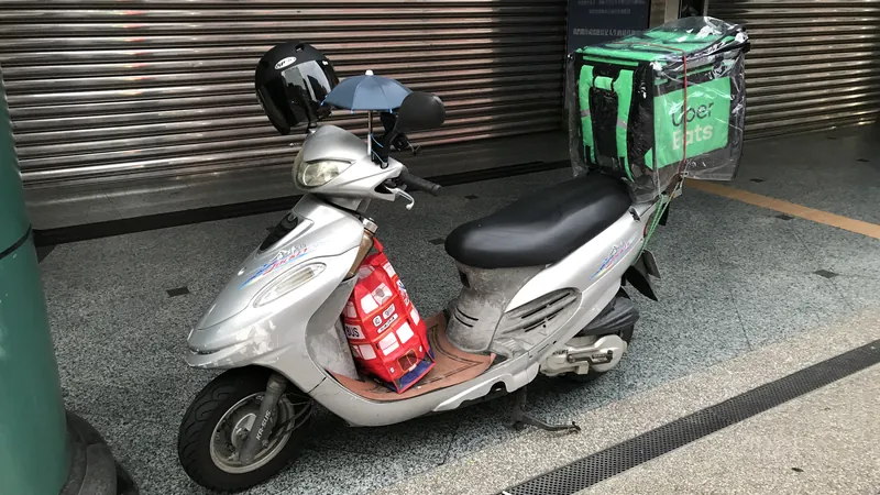停在騎樓鐵捲門前的機車,後座綁著外送保溫箱
